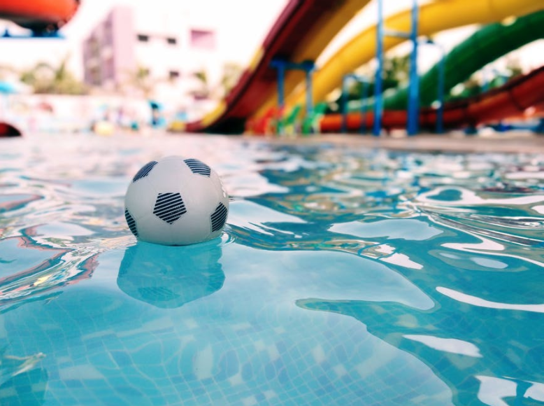 Image of an empty community pool with a ball floating in the swimming pool.